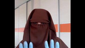 Housekeeper in apron putting on niqab